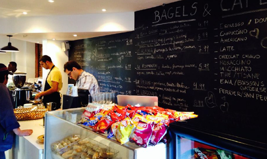 Hinnawi bros bagel restaurant counter with snacks and black chalkboard wall listing menu items