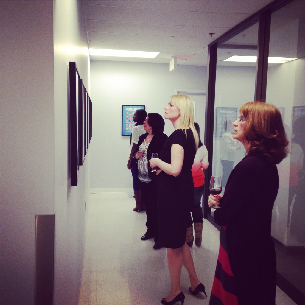 Guests admiring art works displayed on the wall of Souvenirs d’enfance CHUM Vernissage
