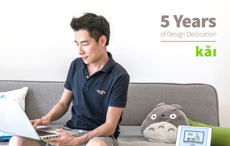 I Kai Andrew Chen sitting at Kai Design waiting area looking at laptop with Totoro sofa cushion